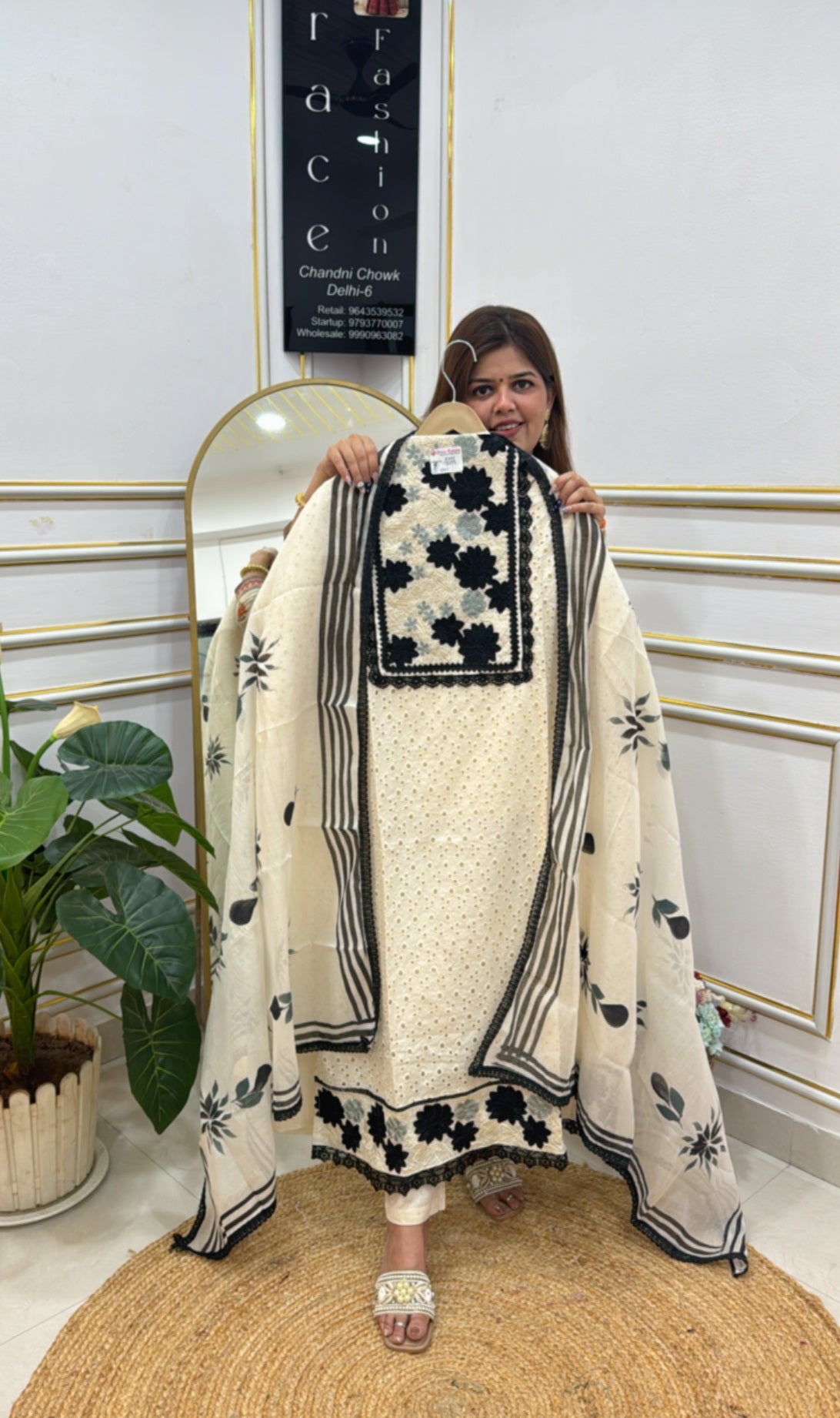 Woman showcasing unstitched ladies suits online with floral embroidery and black accents